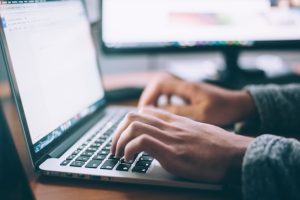 someone typing at a macbook keyboard